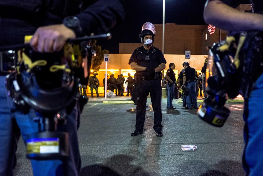 Law enforcement personnel stand guard in front of the El Paso Police Department headquarters building as protestors gathered nearby during a protest over the death of George Floyd, in El Paso, on May 31, 2020.